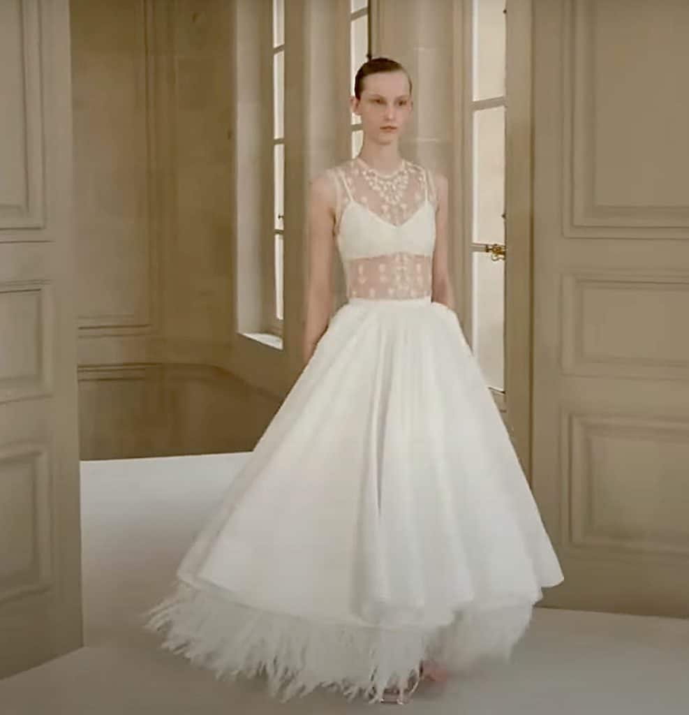 model wearing a white prom dress type of outfit with sheer panels